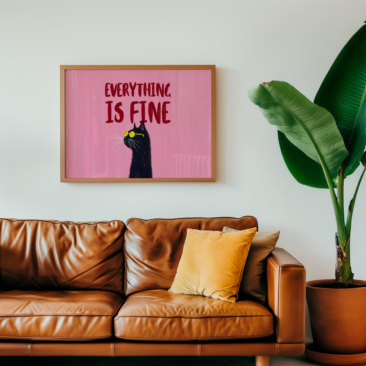 Funny black cat typography print in an oak frame above a cognac leather sofa