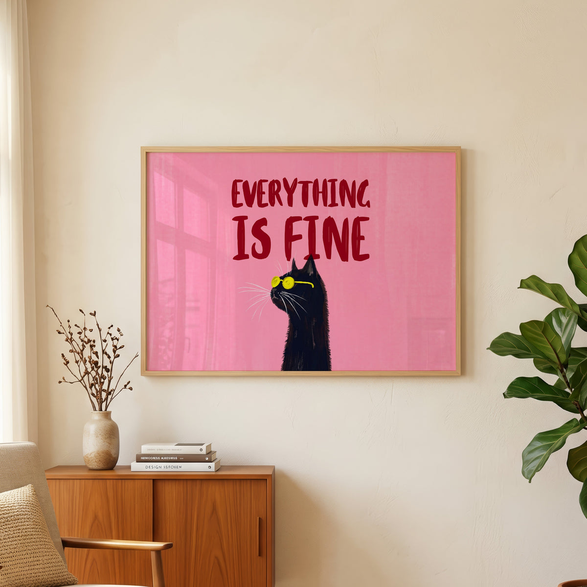 Everything Is Fine quote print in an oak frame above a teak sideboard beside a fig tree