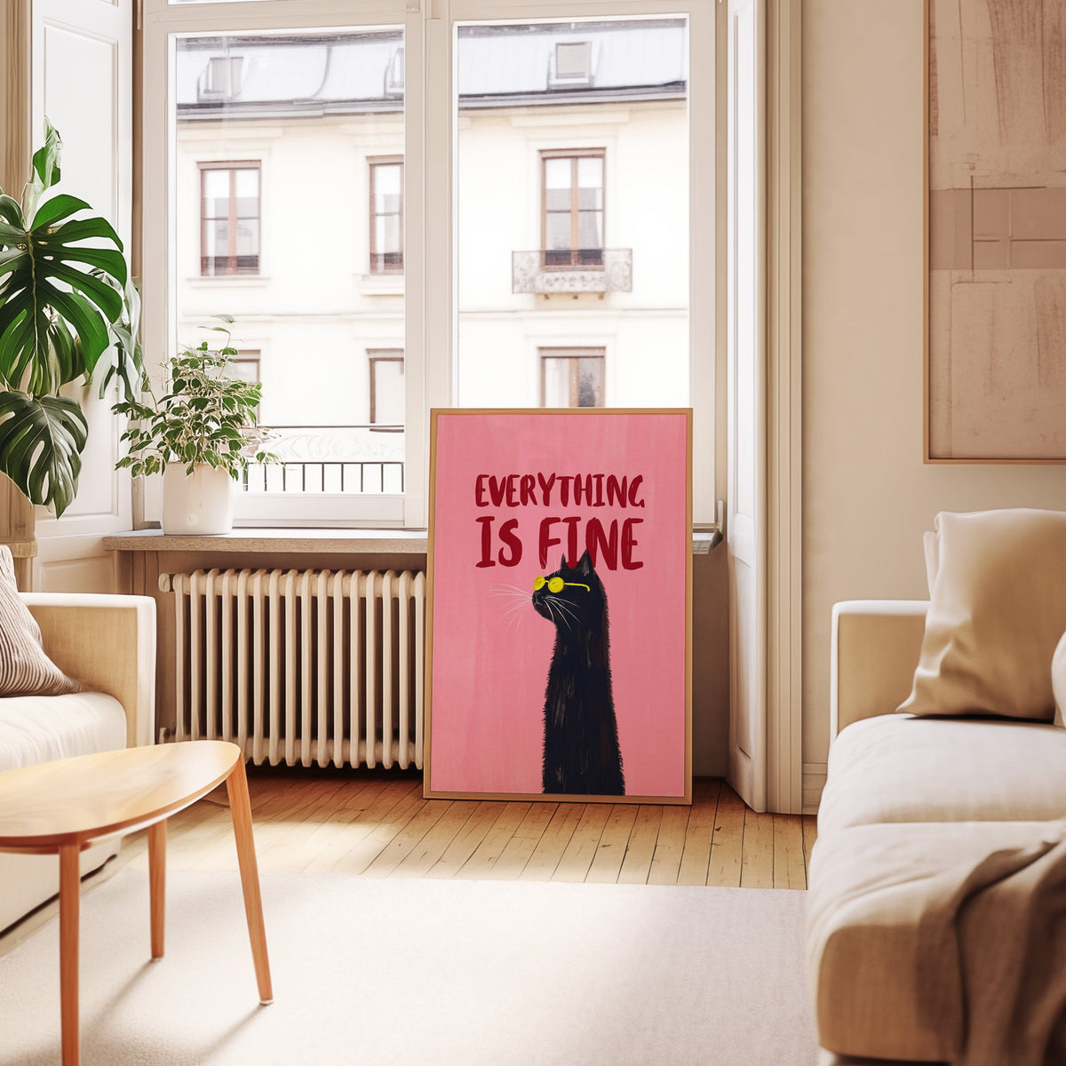 Pink black cat typography print in an oak frame leaning below tall French windows