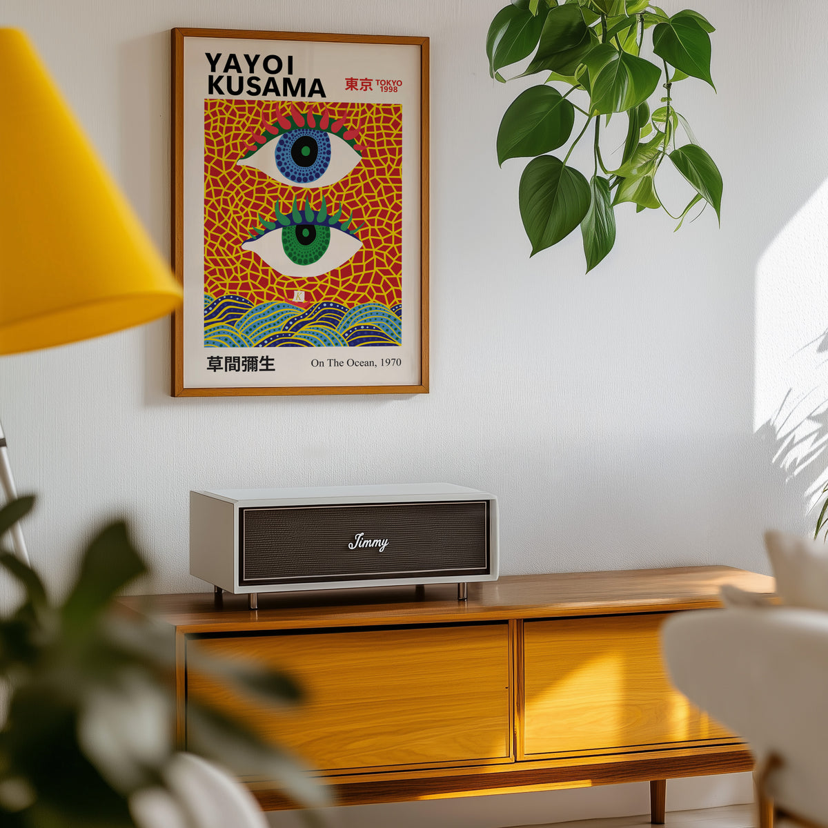 Yayoi Kusama inspired evil eyes and waves print above a sideboard with a plant