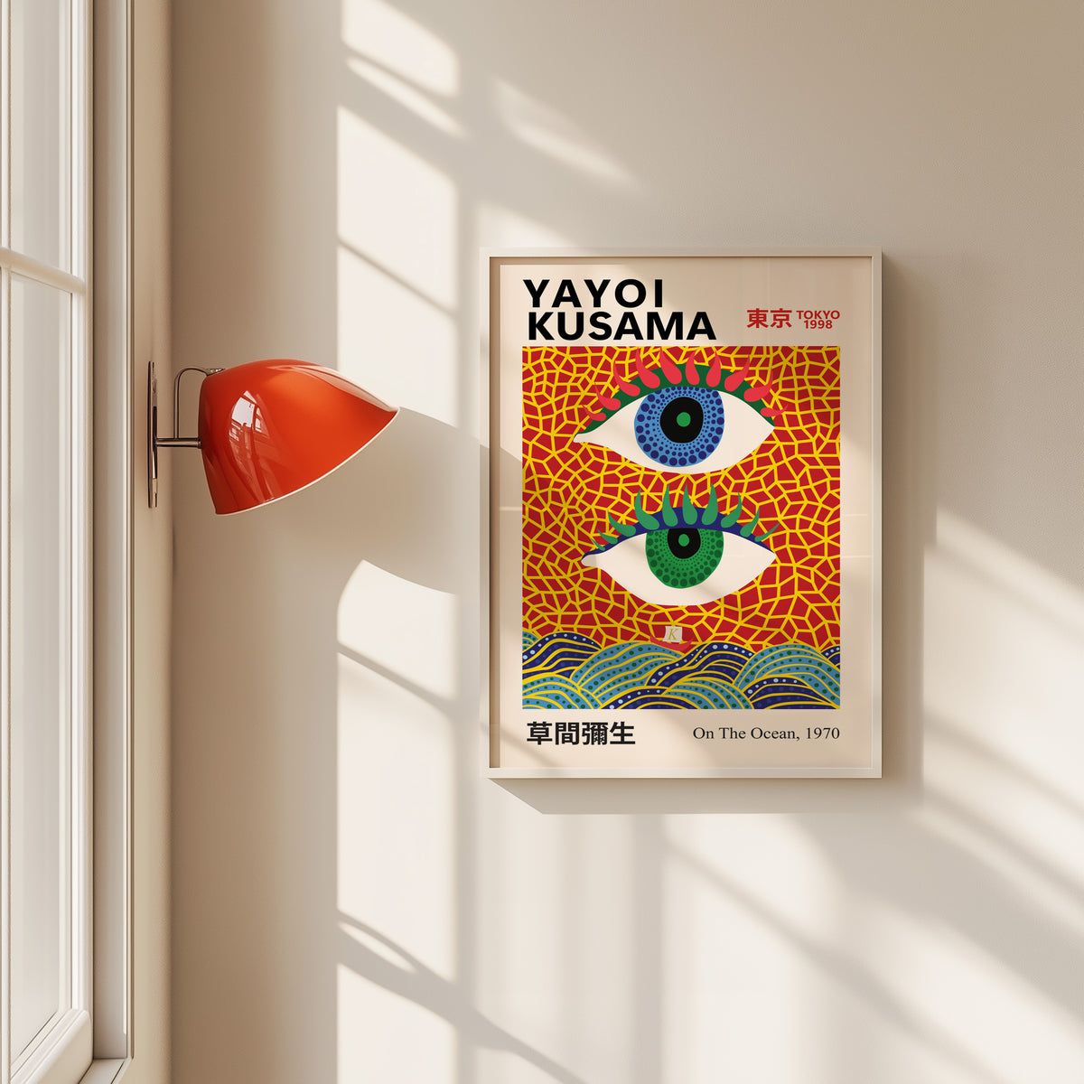 Yayoi Kusama inspired evil eyes and waves print in a white frame by a red wall lamp