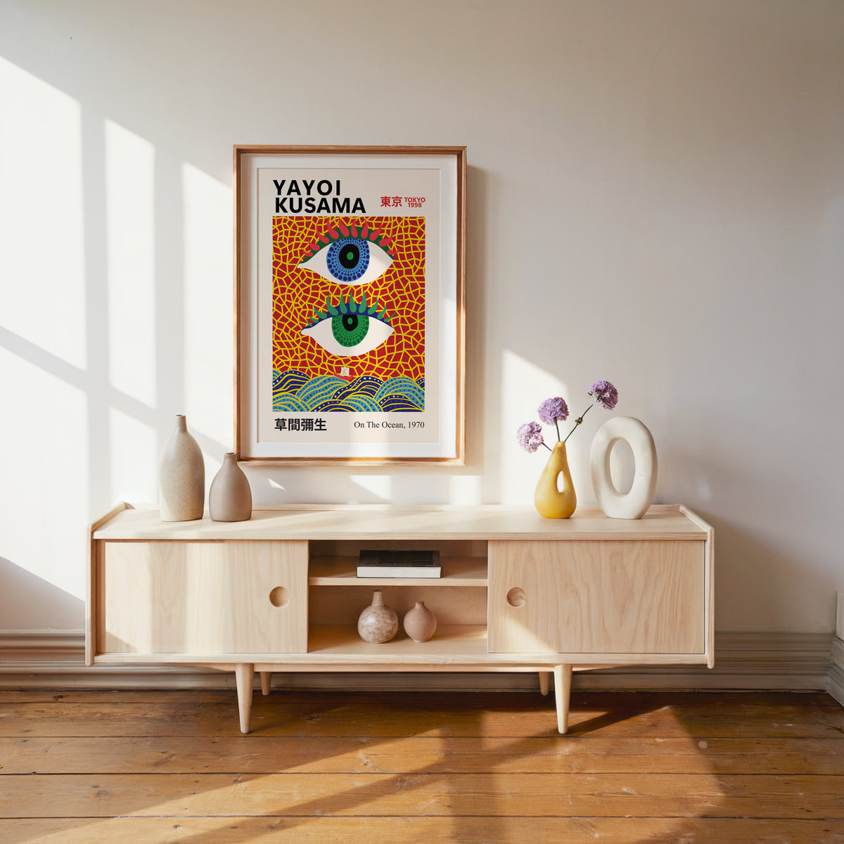 Yayoi Kusama inspired evil eyes and waves print above a pale wood console