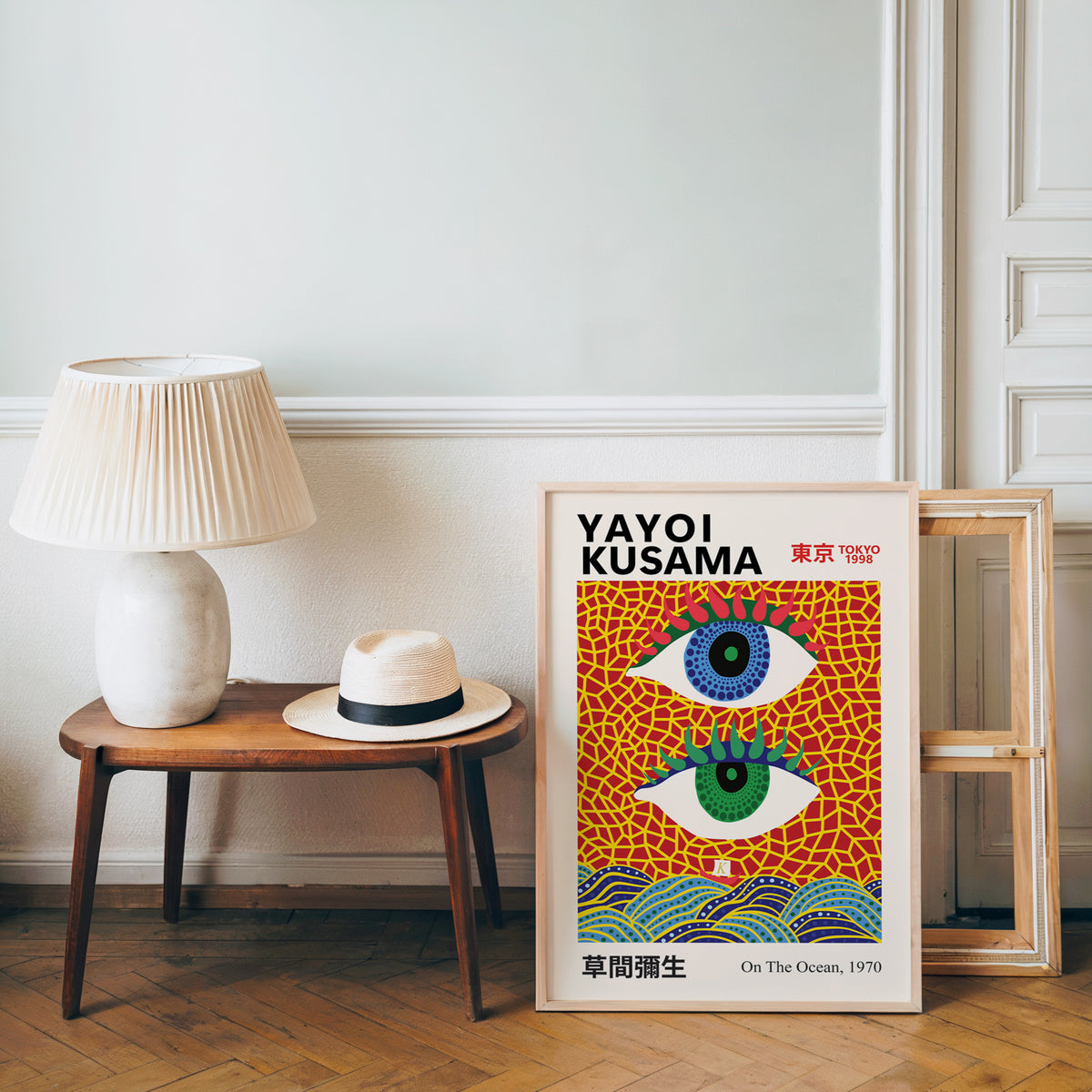 Yayoi Kusama inspired evil eyes and waves print beside a bench and straw hat