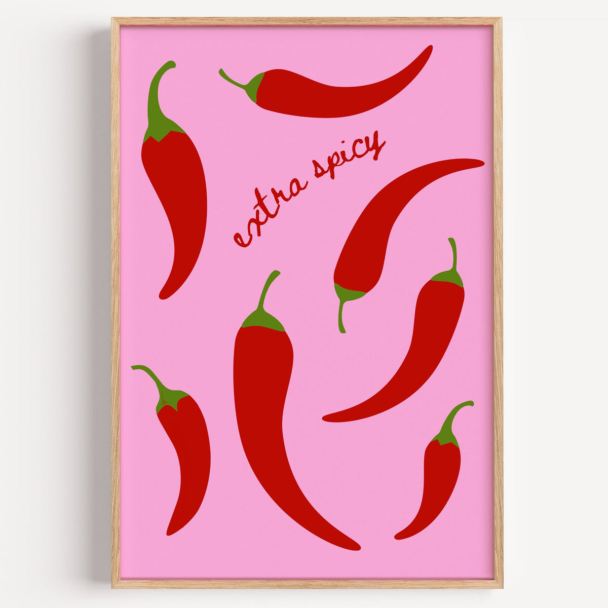 Extra spicy chilli pepper print in a light oak frame on a plain white wall