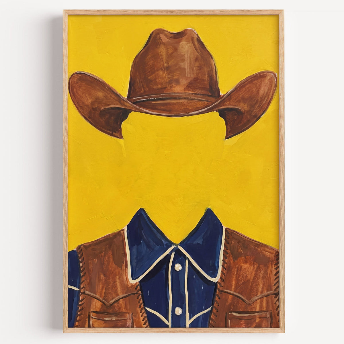 Faceless cowboy print in a light oak frame on a plain white wall
