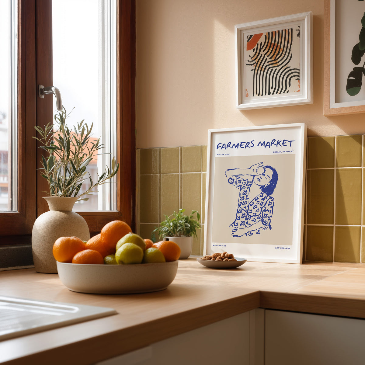 Farmers Market portrait print in a white frame against olive green kitchen tiles