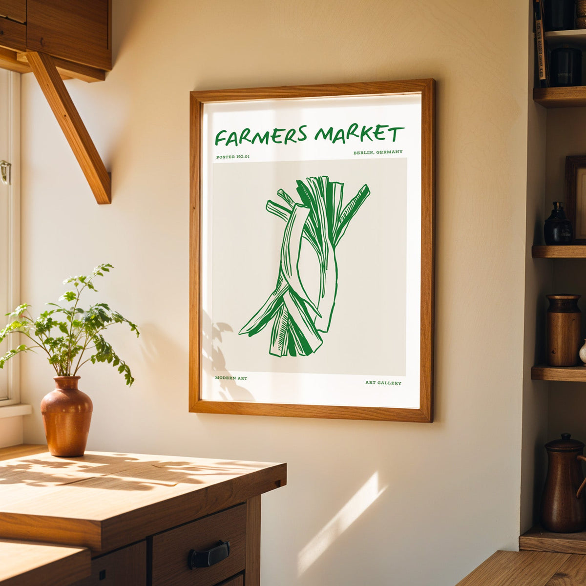 Green leeks farmers market print in a walnut frame on a cream kitchen wall above the island