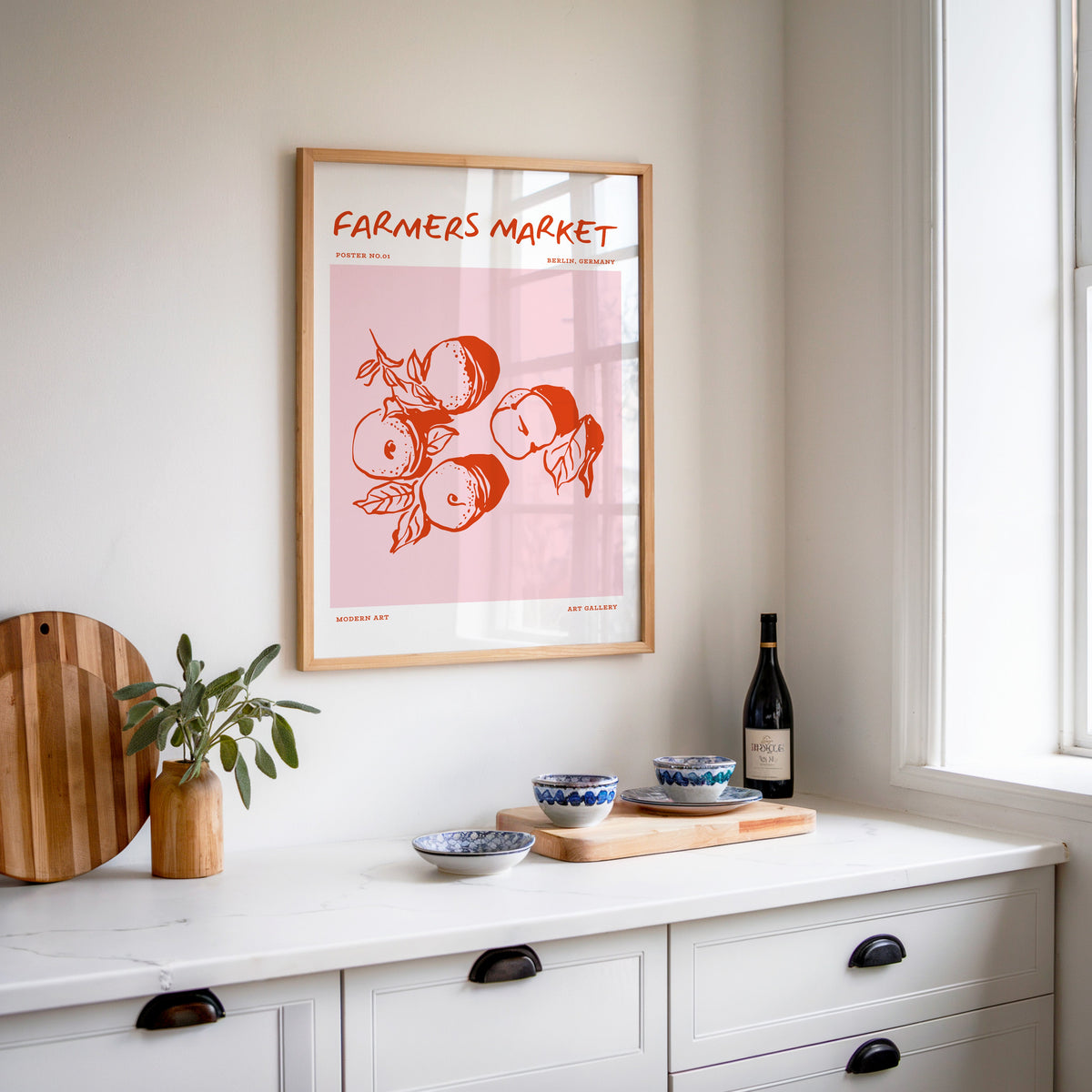 Farmers Market peaches print in an oak frame above a white kitchen sideboard