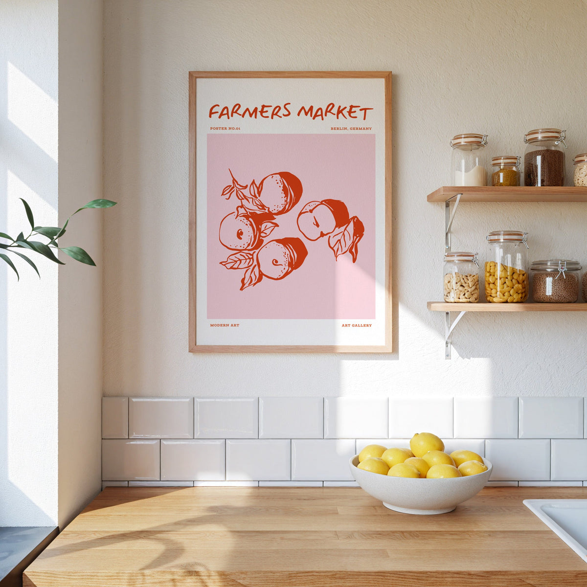 Farmers Market peaches print in an oak frame on a kitchen wall beside open shelves