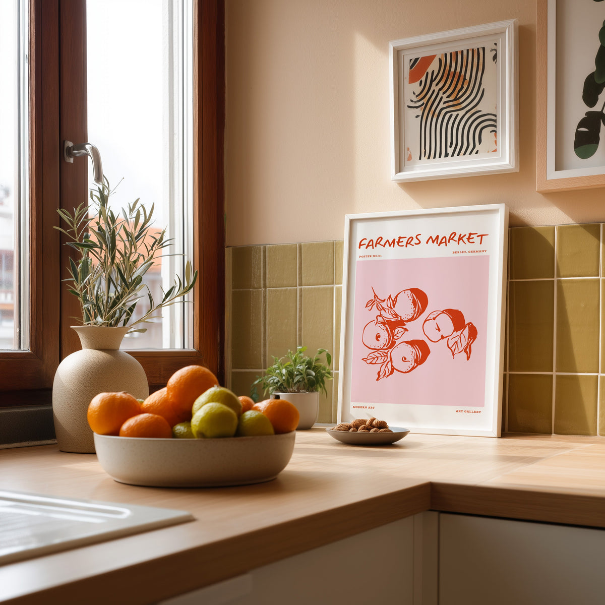 Farmers Market peaches print in a white frame against an olive green tiled kitchen wall