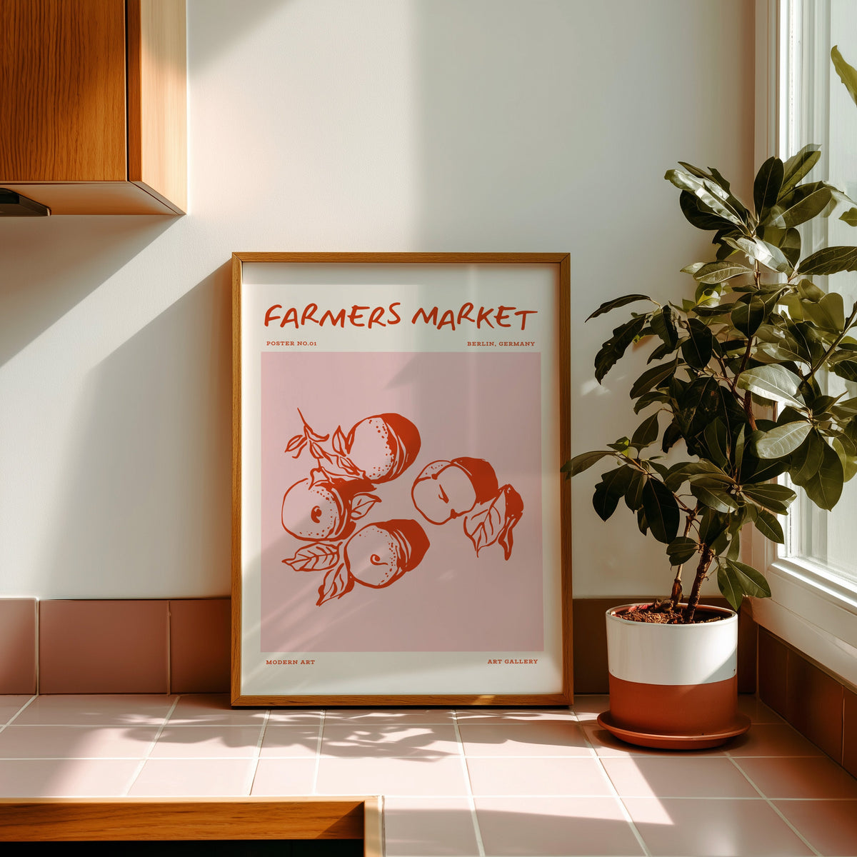 Farmers Market peaches print in an oak frame on pink tiles in strong afternoon sun