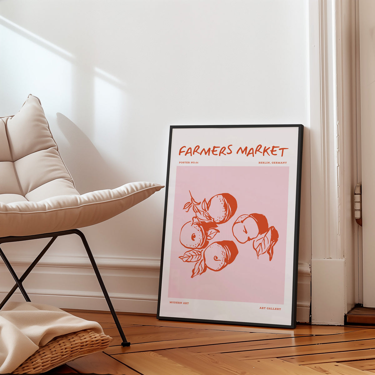 Farmers Market peaches print in a slim black frame on a parquet floor by a boucle chair