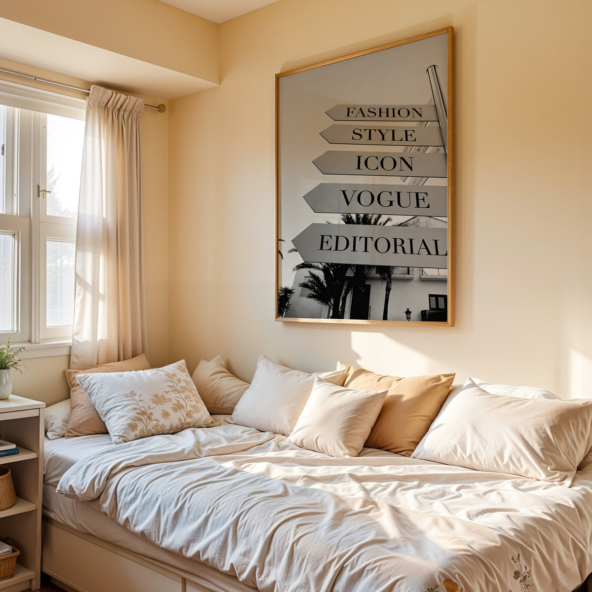 Street signpost with fashion words above palm trees print in an oak frame above a cream daybed in a sunny bedroom