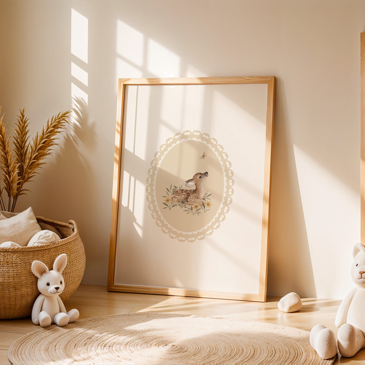 Fawn watching a butterfly in a lace oval nursery print in an oak frame leaning on a sunlit floor by a woven basket