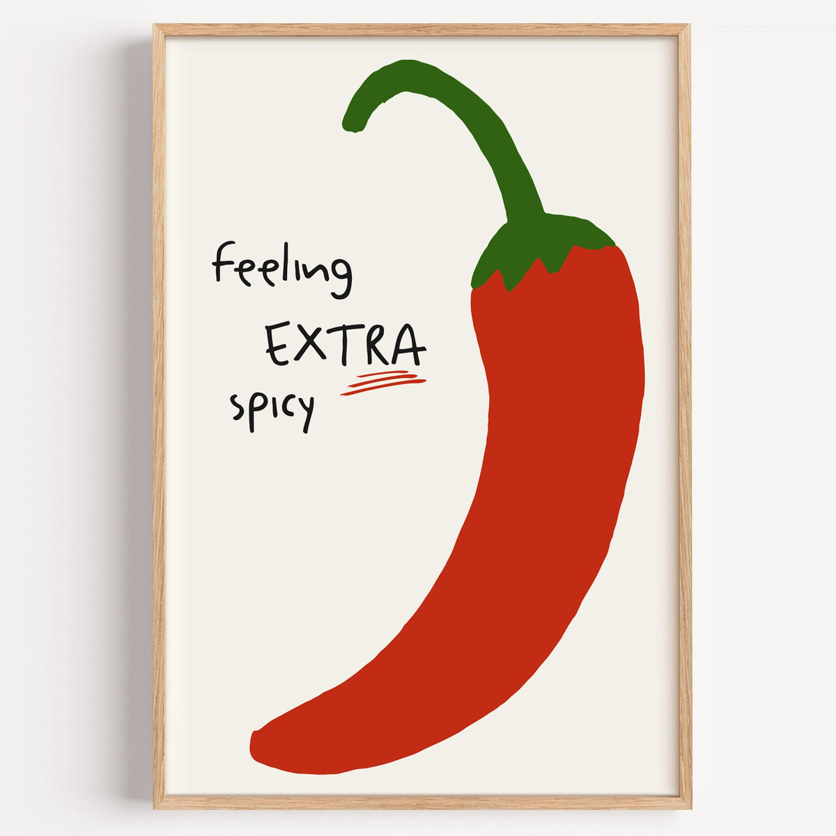 Feeling extra spicy chili print in a light oak frame on a plain white wall