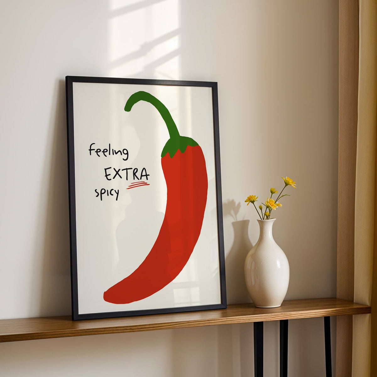 Feeling extra spicy chili print in a black frame on a console table with yellow daisies