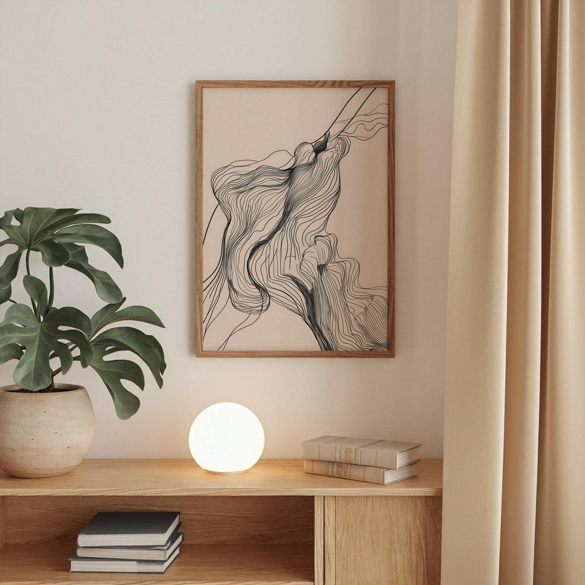 Fine line flowing contour line art print in a walnut frame above an oak cabinet with a glowing globe lamp