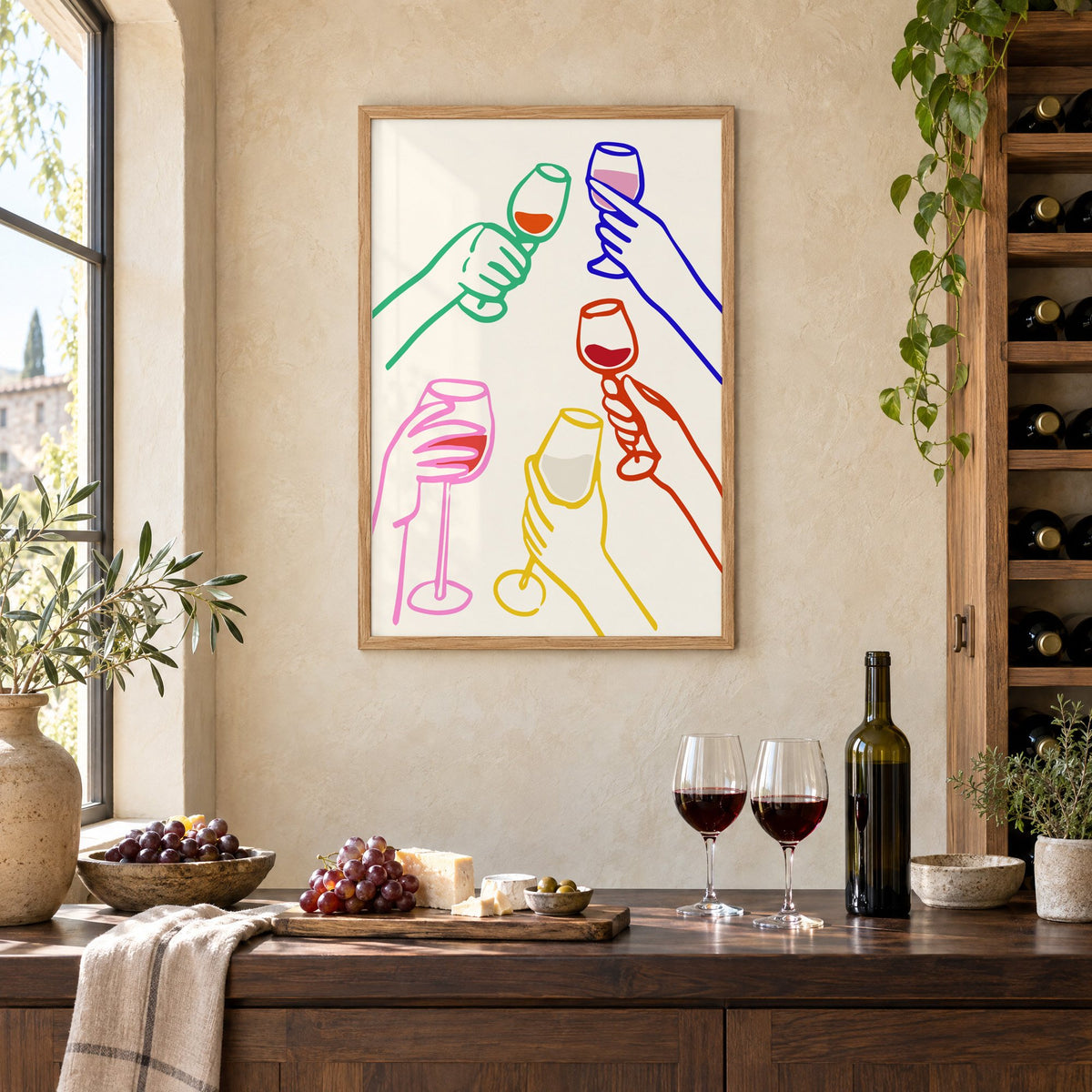 Five hands colorful line wine toast print in an oak frame on a limewashed wall above a wine counter with red wine, cheese and grapes