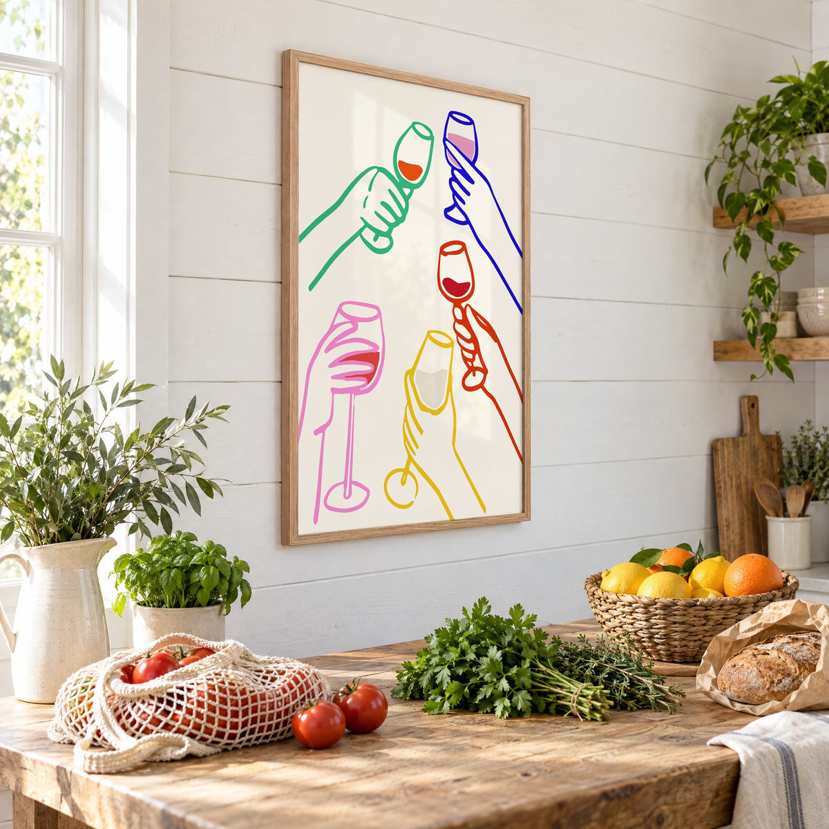 Five hands colorful line wine toast print in an oak frame on a shiplap wall above a farm table with market tomatoes and citrus, seen at an angle