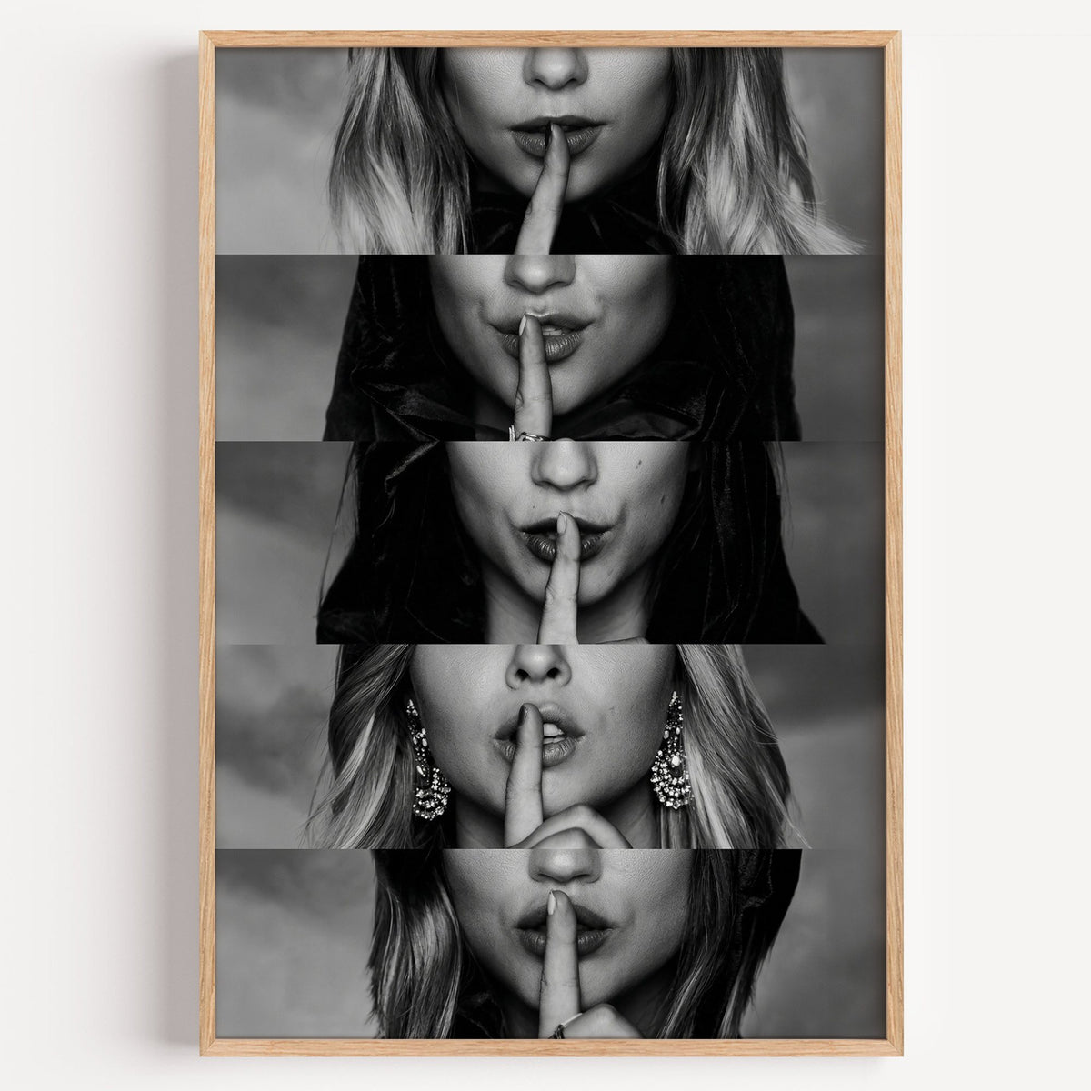 Five stacked strips of finger to lips hush print in a light oak frame on a plain white wall