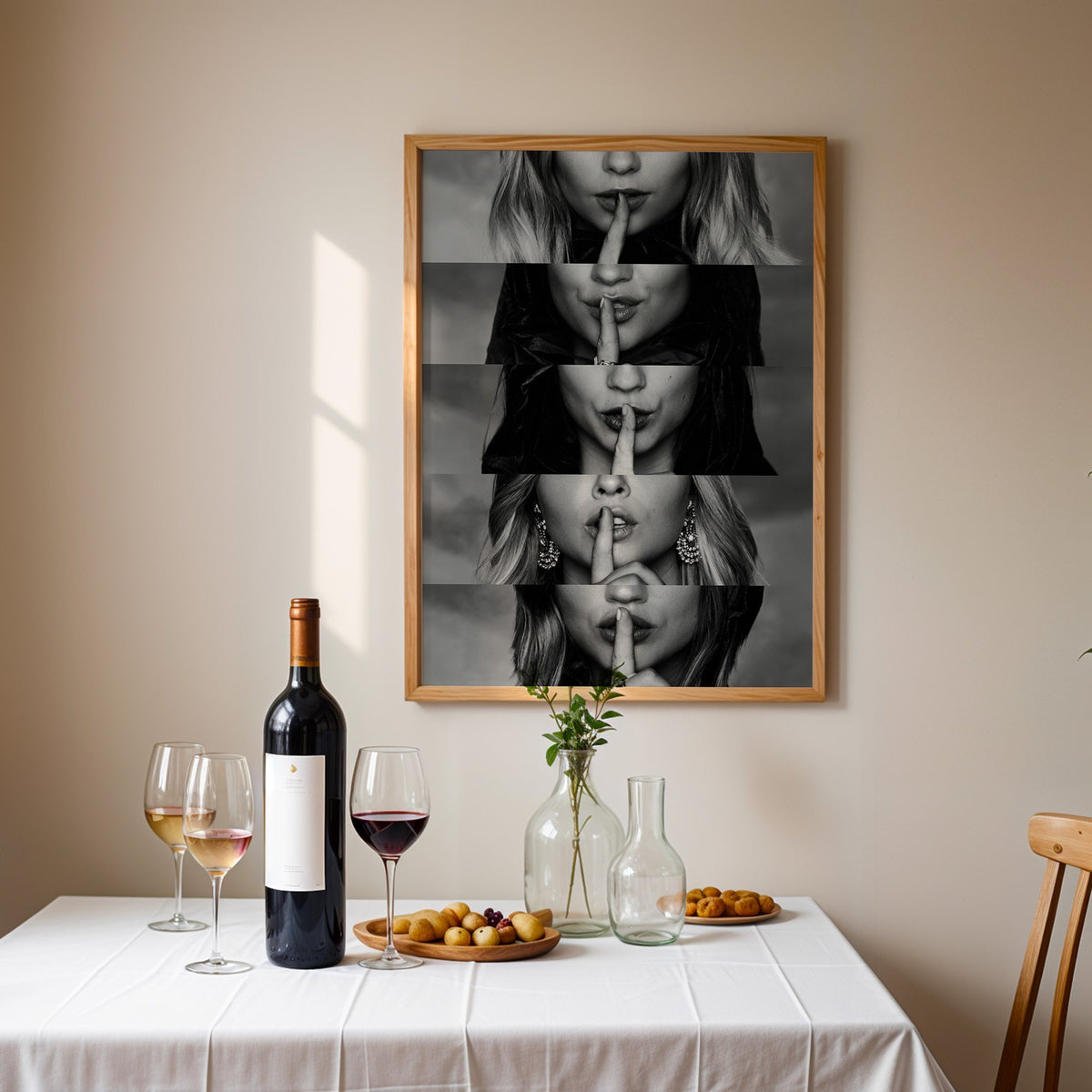 Five stacked strips of finger to lips hush print in an oak frame above a table set with red wine and glasses