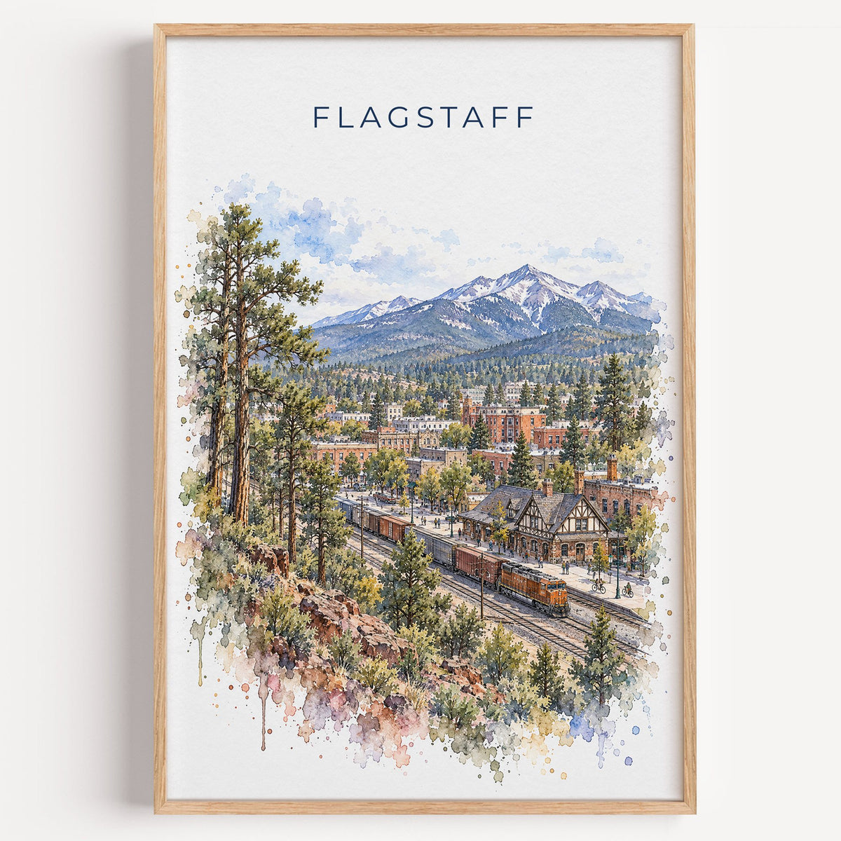 Flagstaff watercolor print in a light oak frame on a plain white wall