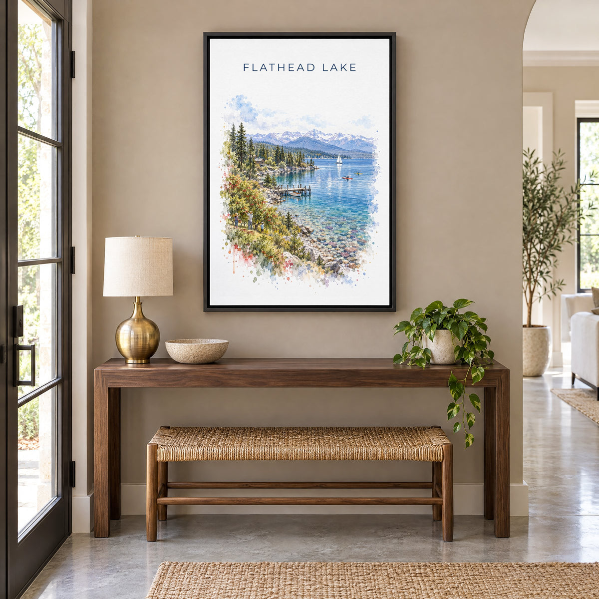 Flathead Lake watercolor print as a black floater canvas above a walnut console and woven bench in an entryway