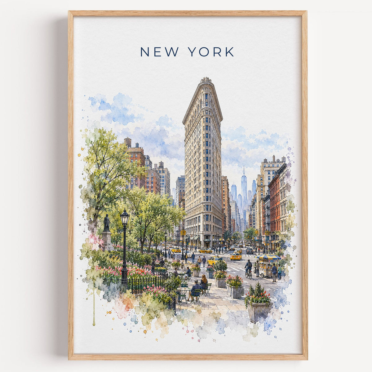 Flatiron Building watercolor print in a light oak frame on a plain white wall