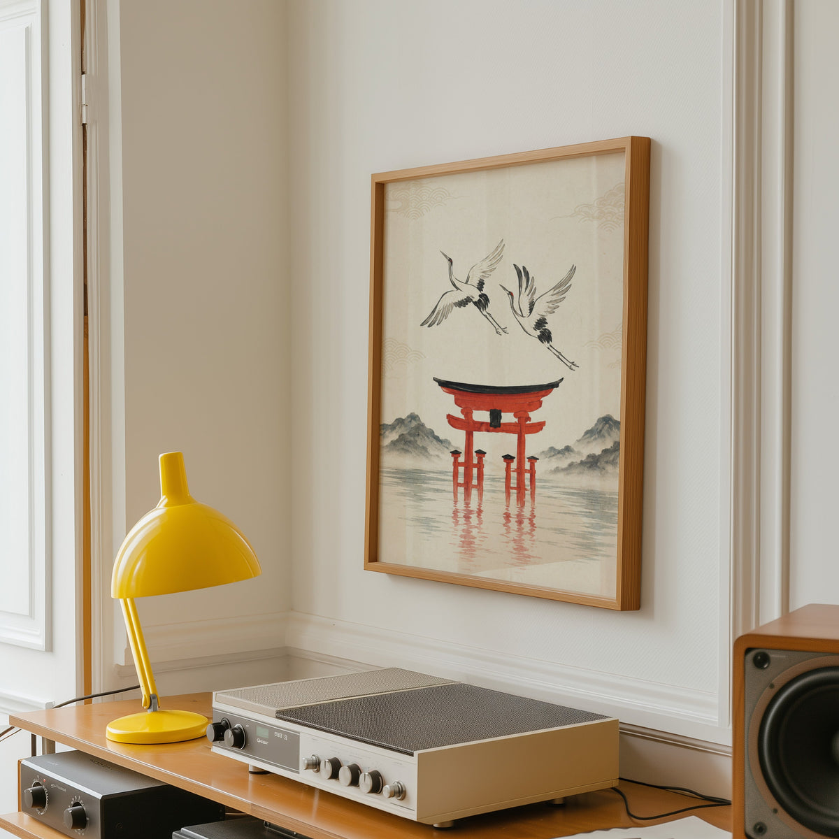 red torii gate with cranes print in an oak frame above a vintage hi-fi shelf with a yellow desk lamp