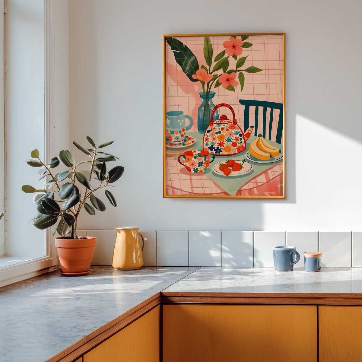 Floral teapot print in a gold frame above a marble counter with a yellow ceramic jug