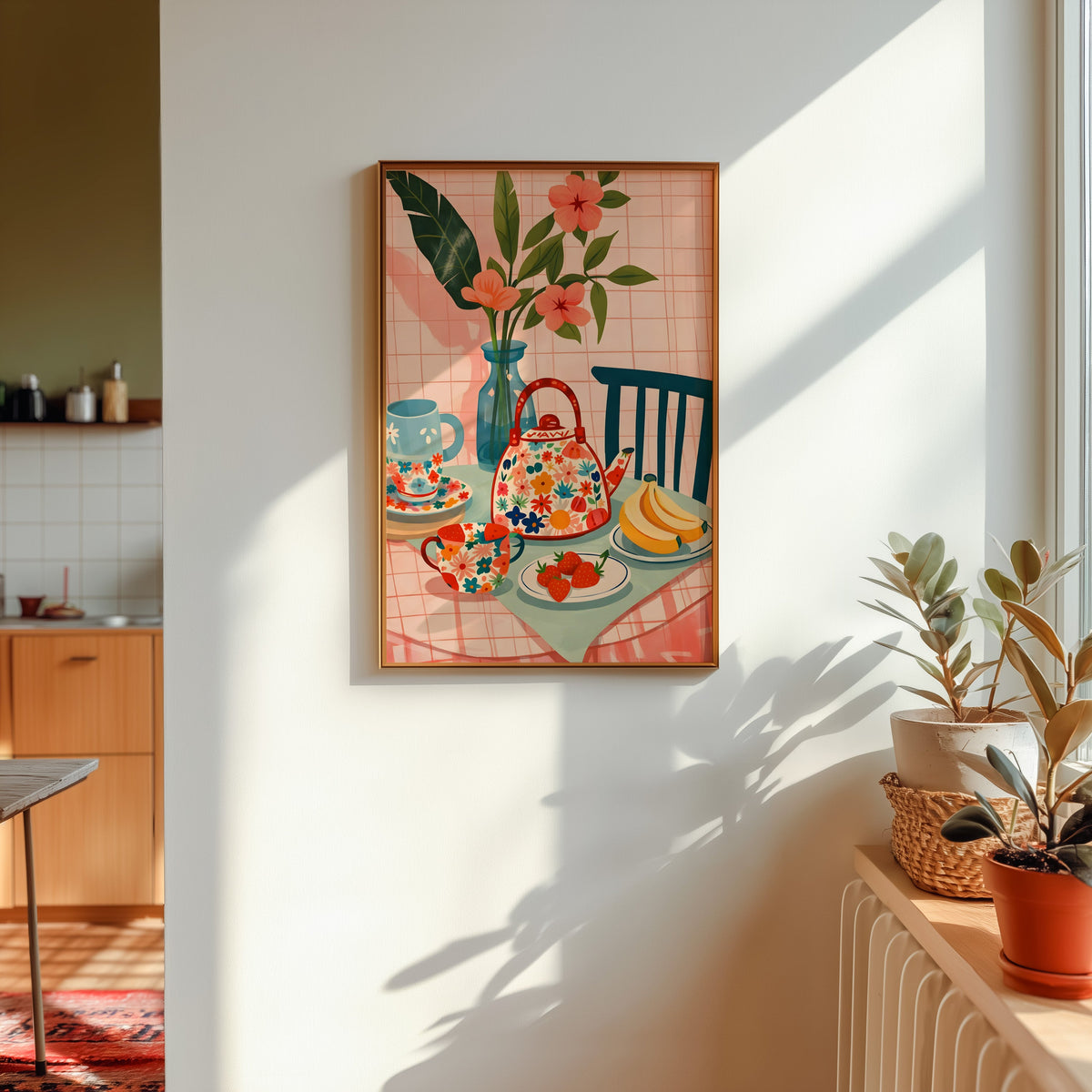 Floral teapot print in a gold frame in sunlight with plants on the ledge and a kitchen beyond
