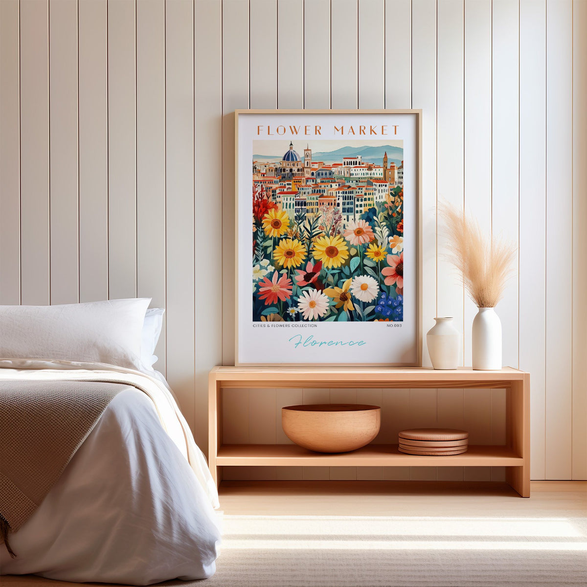 Florence flower market print in an oak frame on a wood bench against a white shiplap bedroom wall with pampas grass