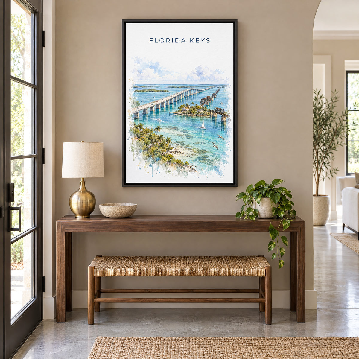 Florida Keys watercolor print as a black floater canvas above a walnut console and woven bench in an entryway