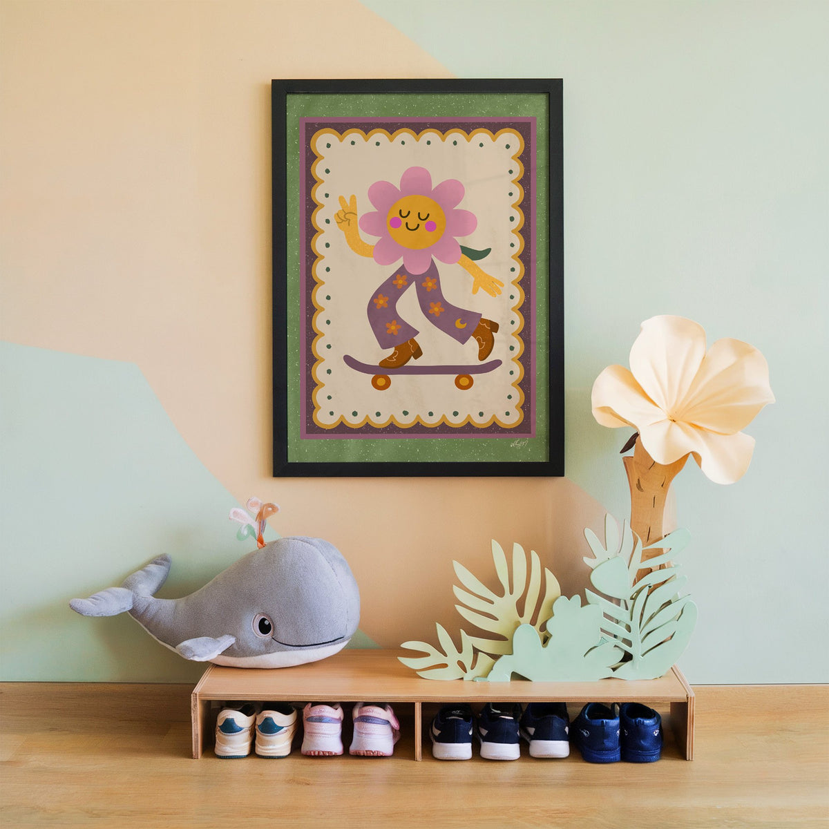 Groovy flower on skateboard nursery print in a black frame on a mint and peach wall above a whale plush