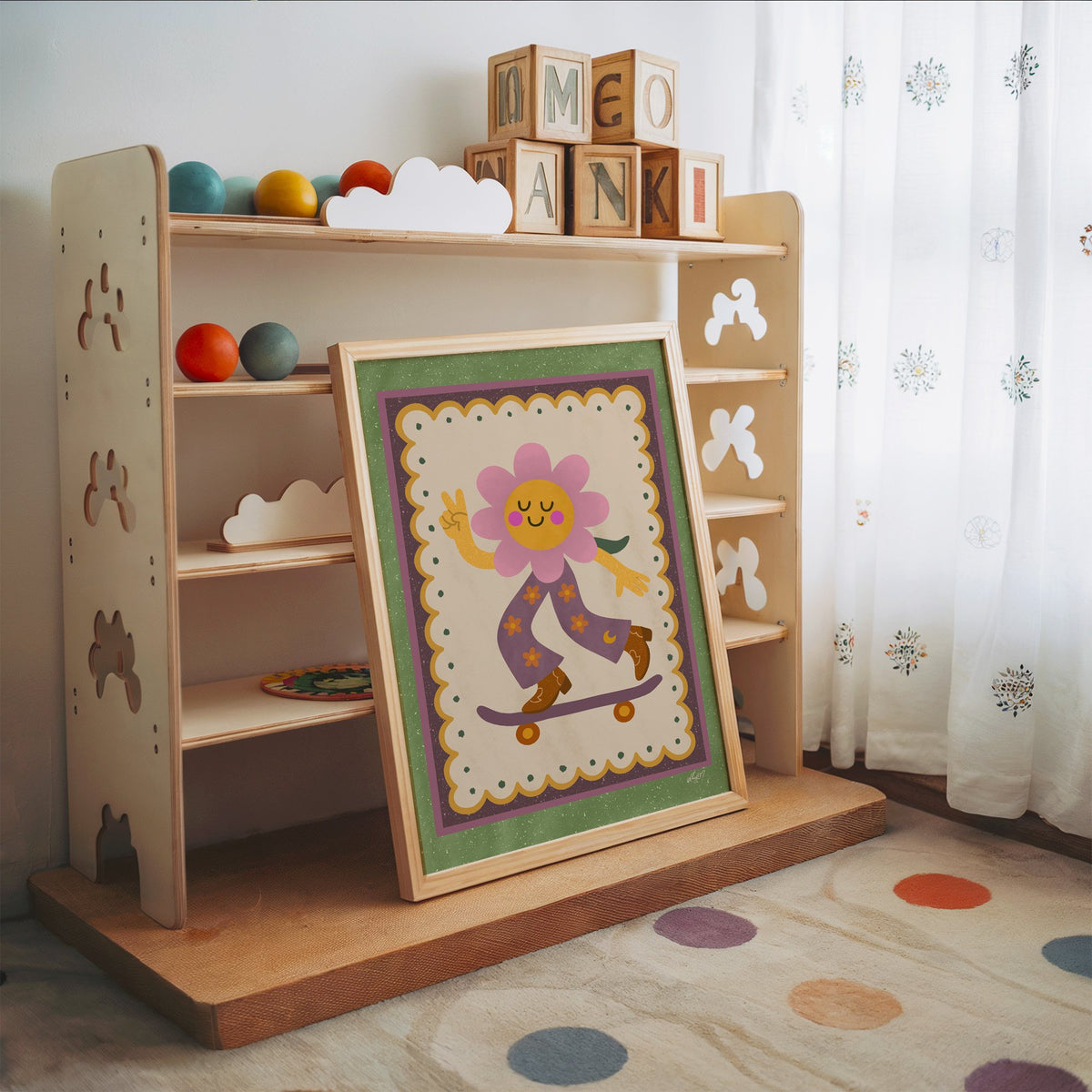 Groovy flower on skateboard nursery print in an oak frame leaning on a toy shelf with wooden letter blocks