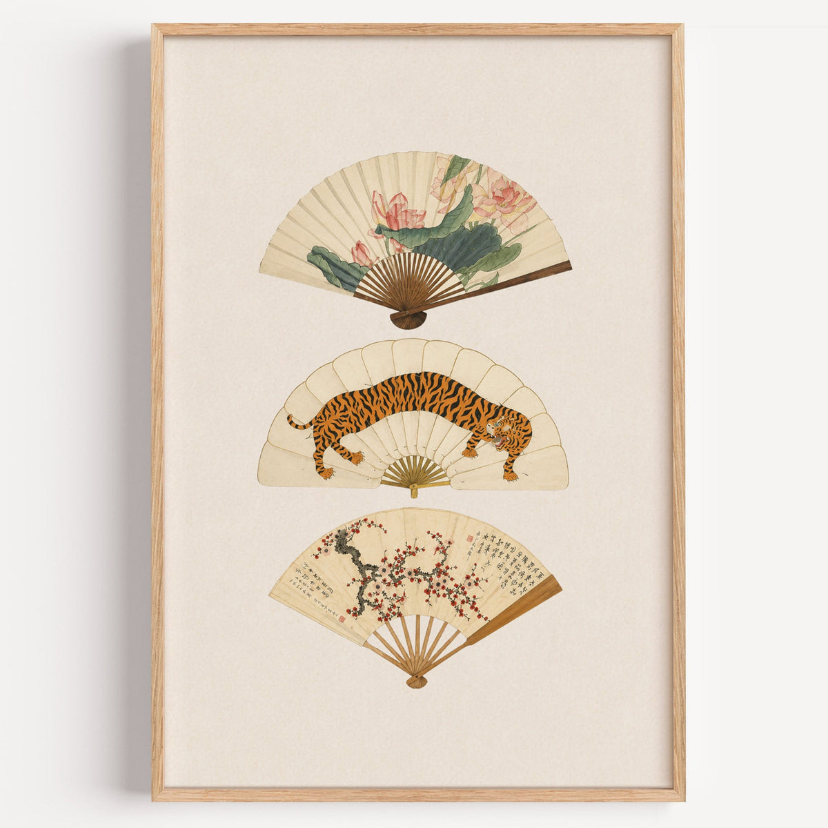 three painted hand fans print in a light oak frame on a plain white wall