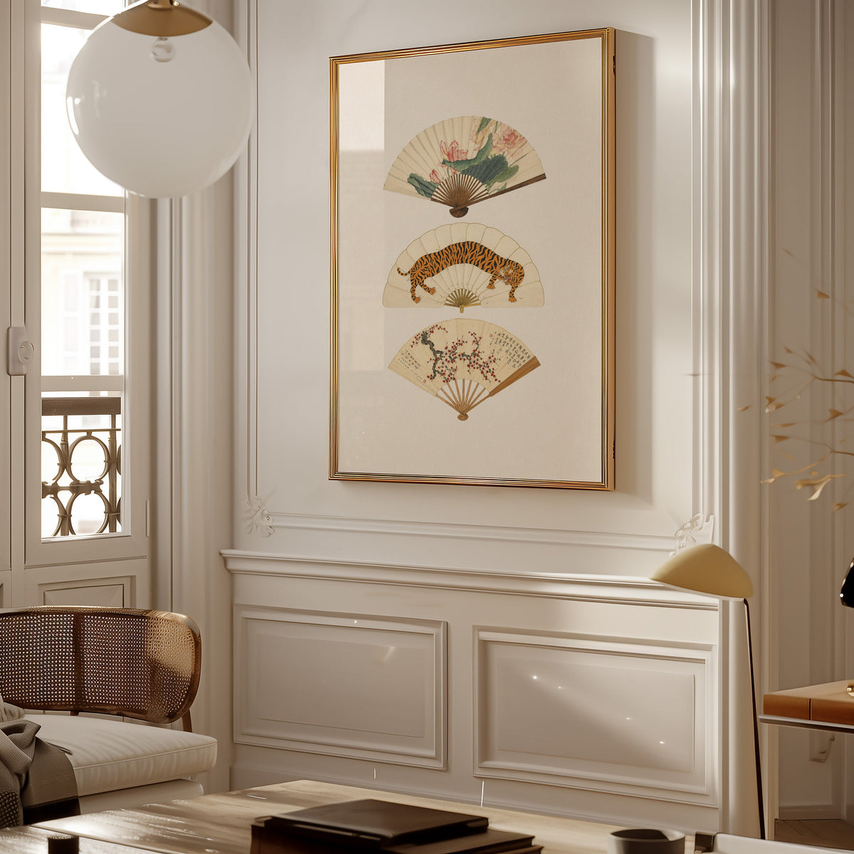 three painted hand fans print shown in a gold frame on a paneled wall in a Parisian-style living room