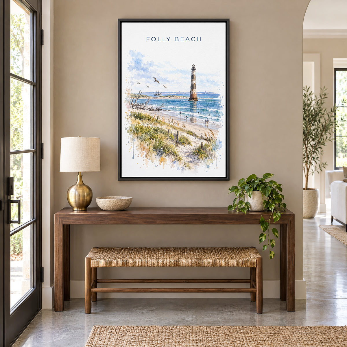 Folly Beach watercolor print as a black floater canvas above a walnut console and woven bench in an entryway