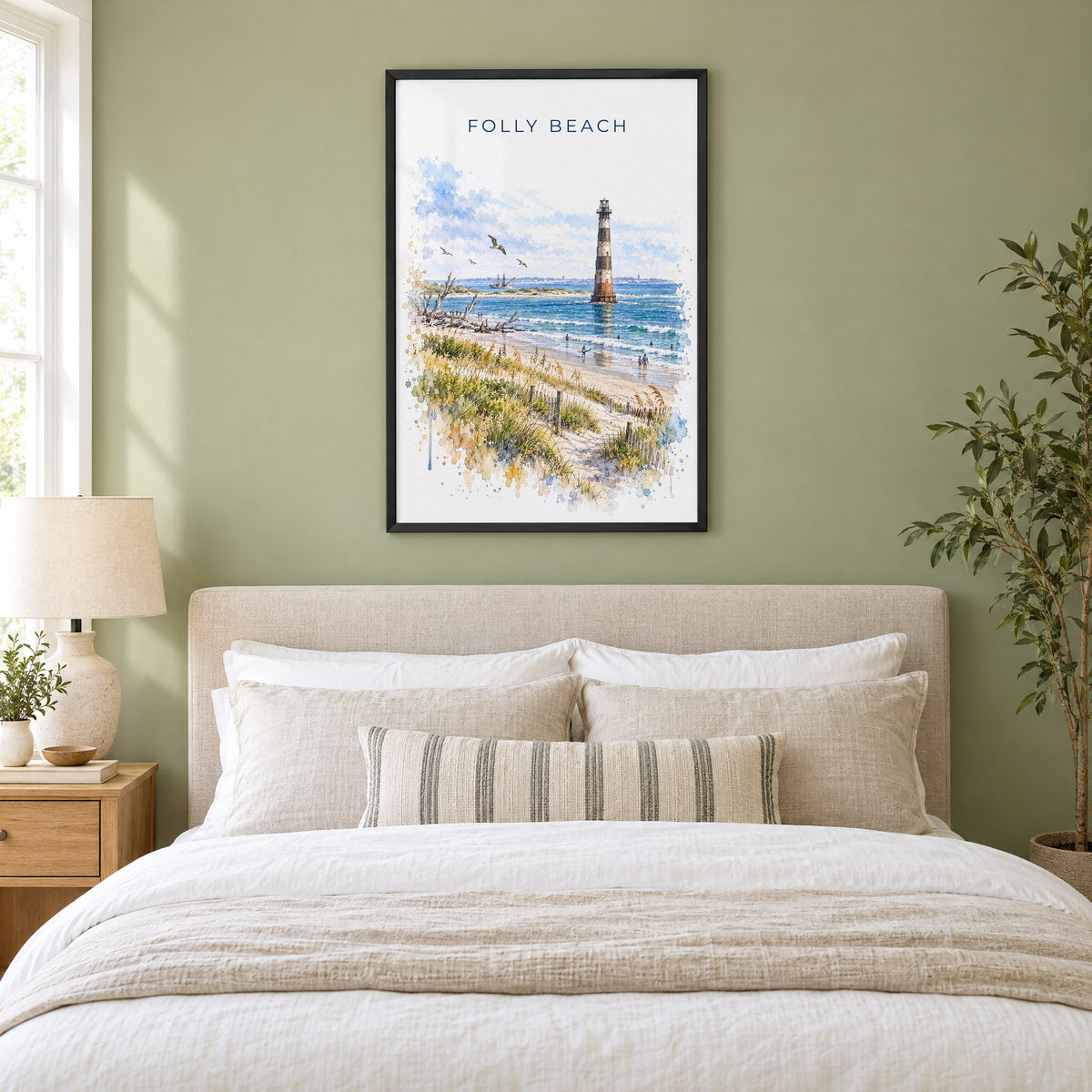 Folly Beach watercolor print in a black frame above an upholstered headboard in a sage green bedroom