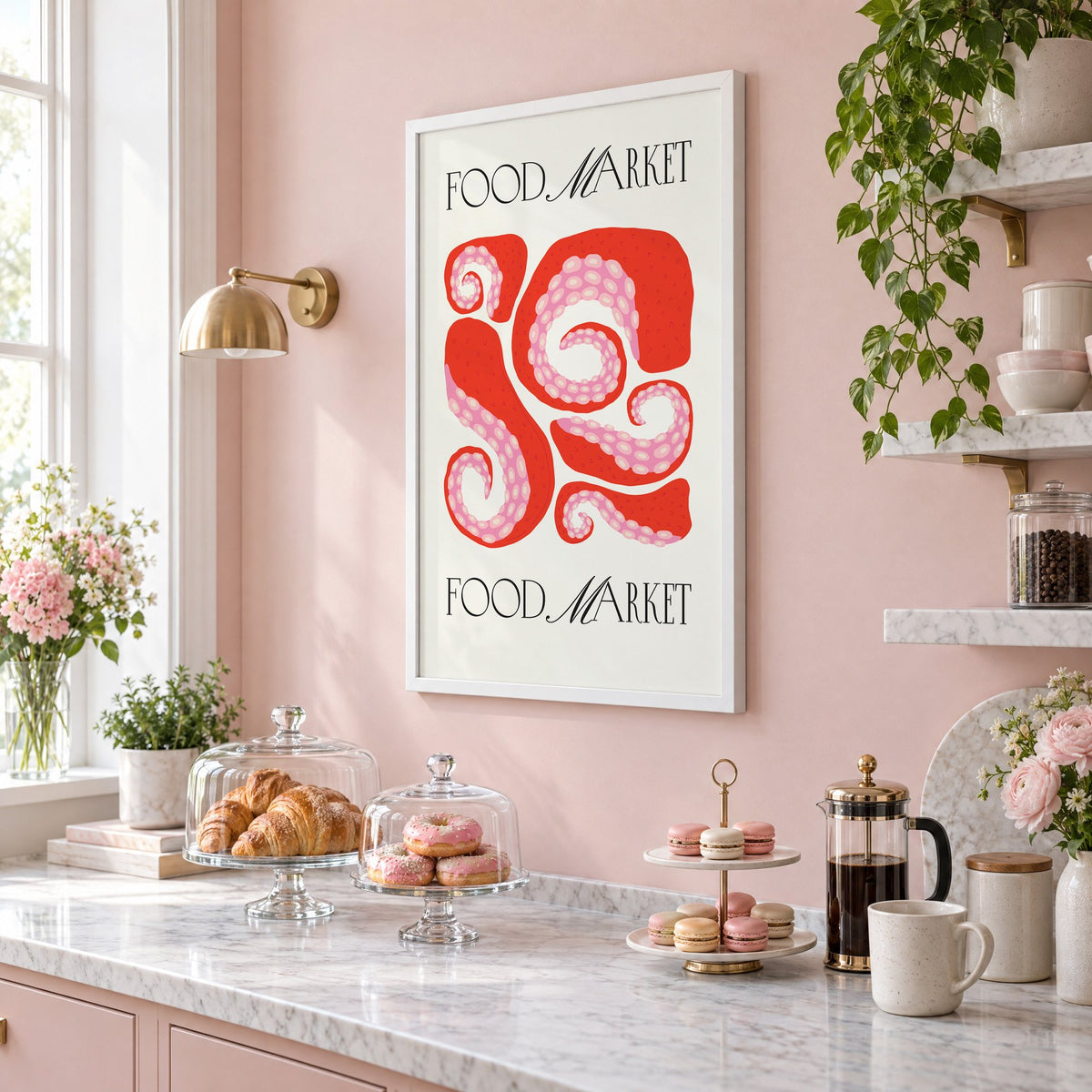 FOOD MARKET red octopus tentacles print in a white frame on a blush pink wall above a patisserie counter with croissants and macarons, seen at an angle