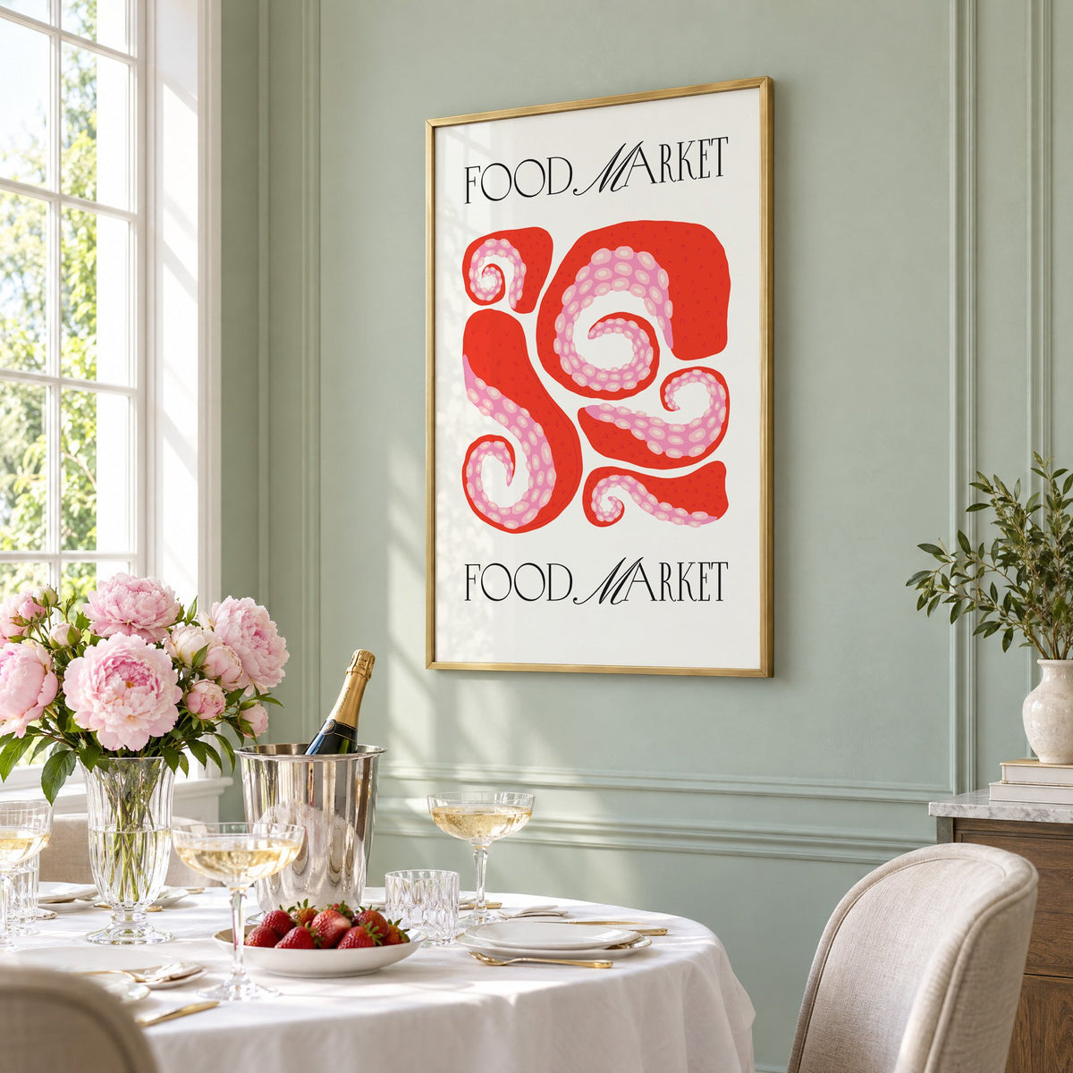 FOOD MARKET red octopus tentacles print in a brass frame on a sage wall above a brunch table with champagne and peonies, seen at an angle