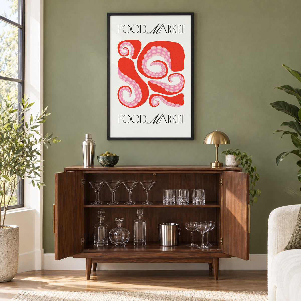 FOOD MARKET red octopus tentacles print in a black frame on an olive green wall above a walnut bar cabinet with glassware