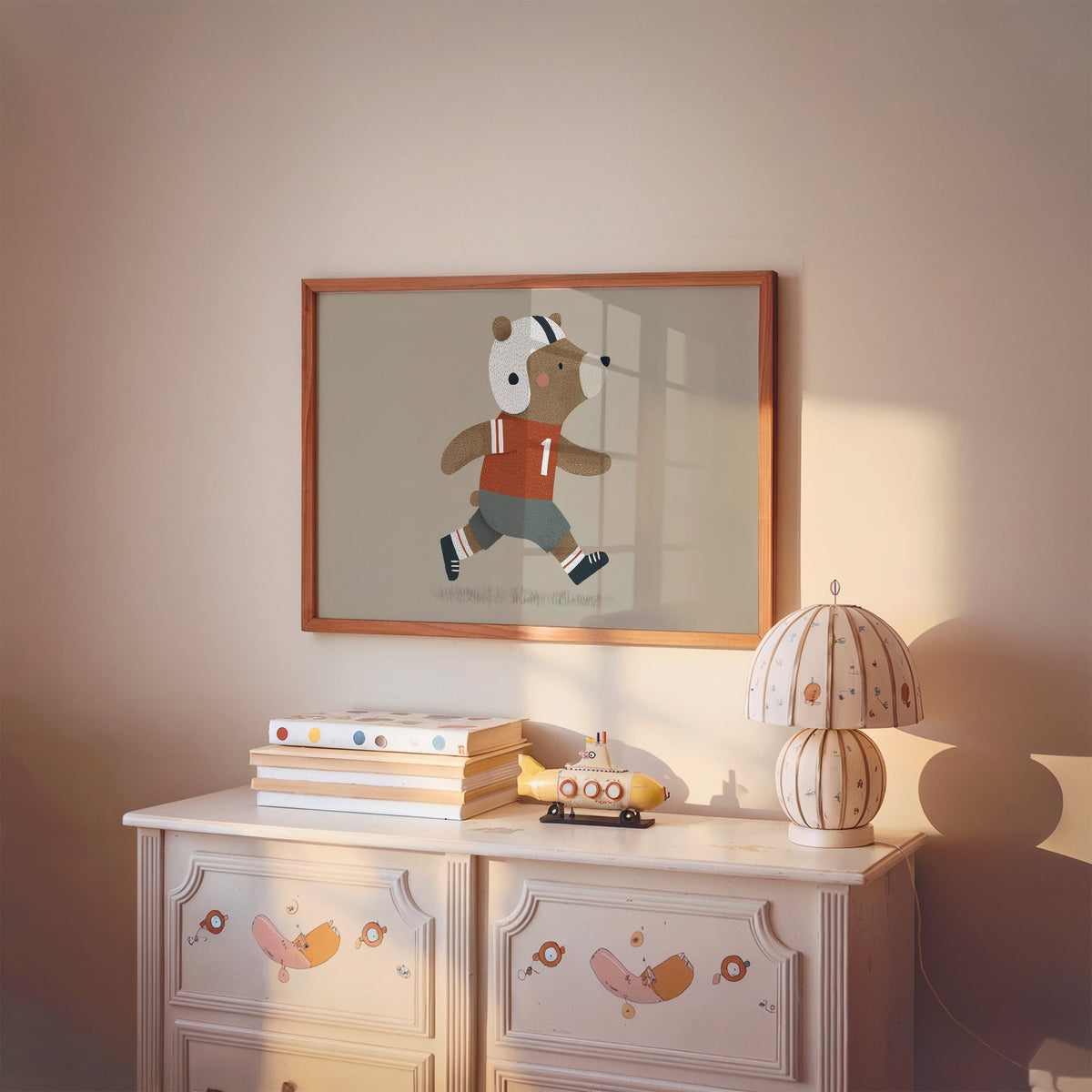 Landscape football bear number one nursery print in a cherry wood frame above a painted dresser and lamp
