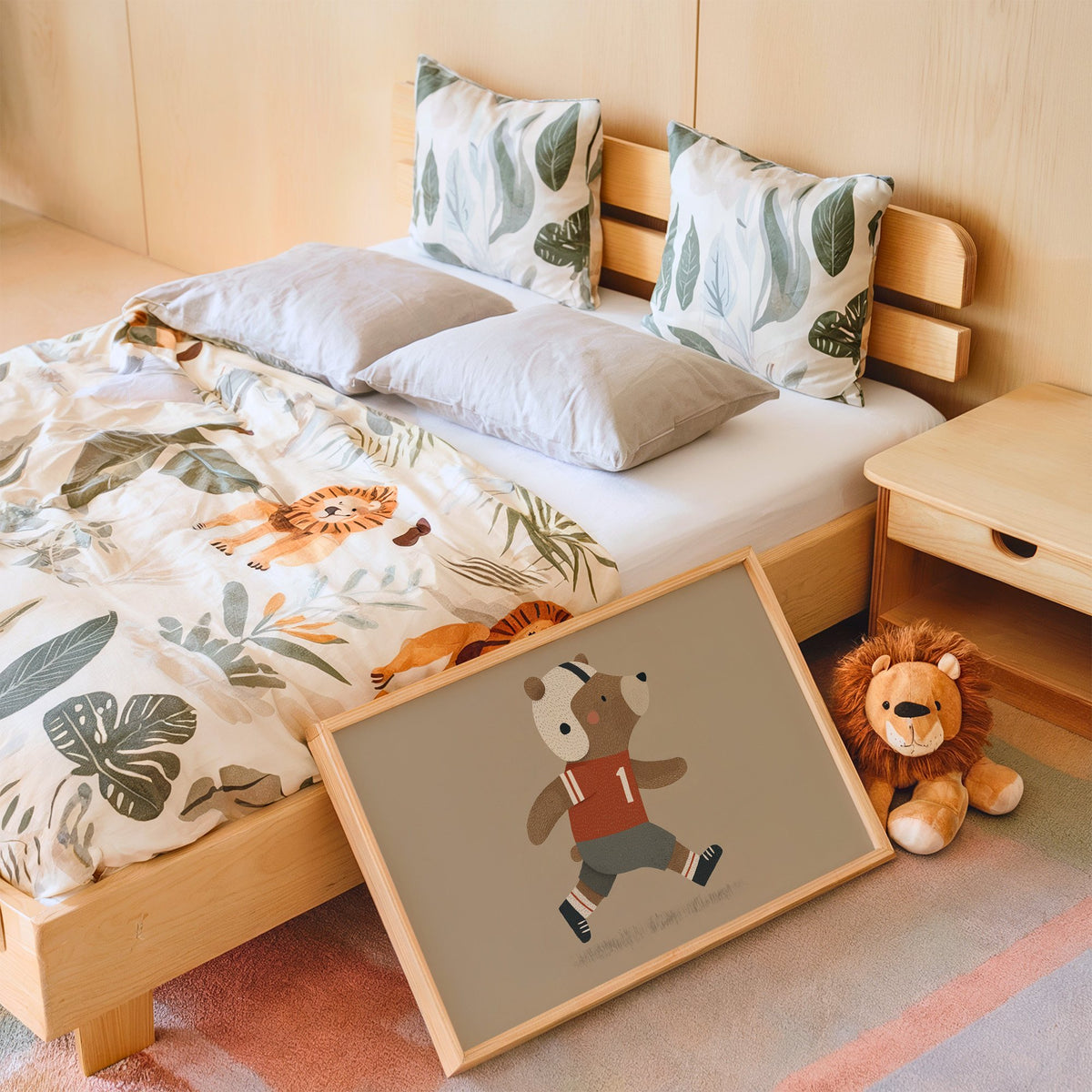 Landscape football bear number one nursery print in an oak frame leaning on a kids bed by a lion plush
