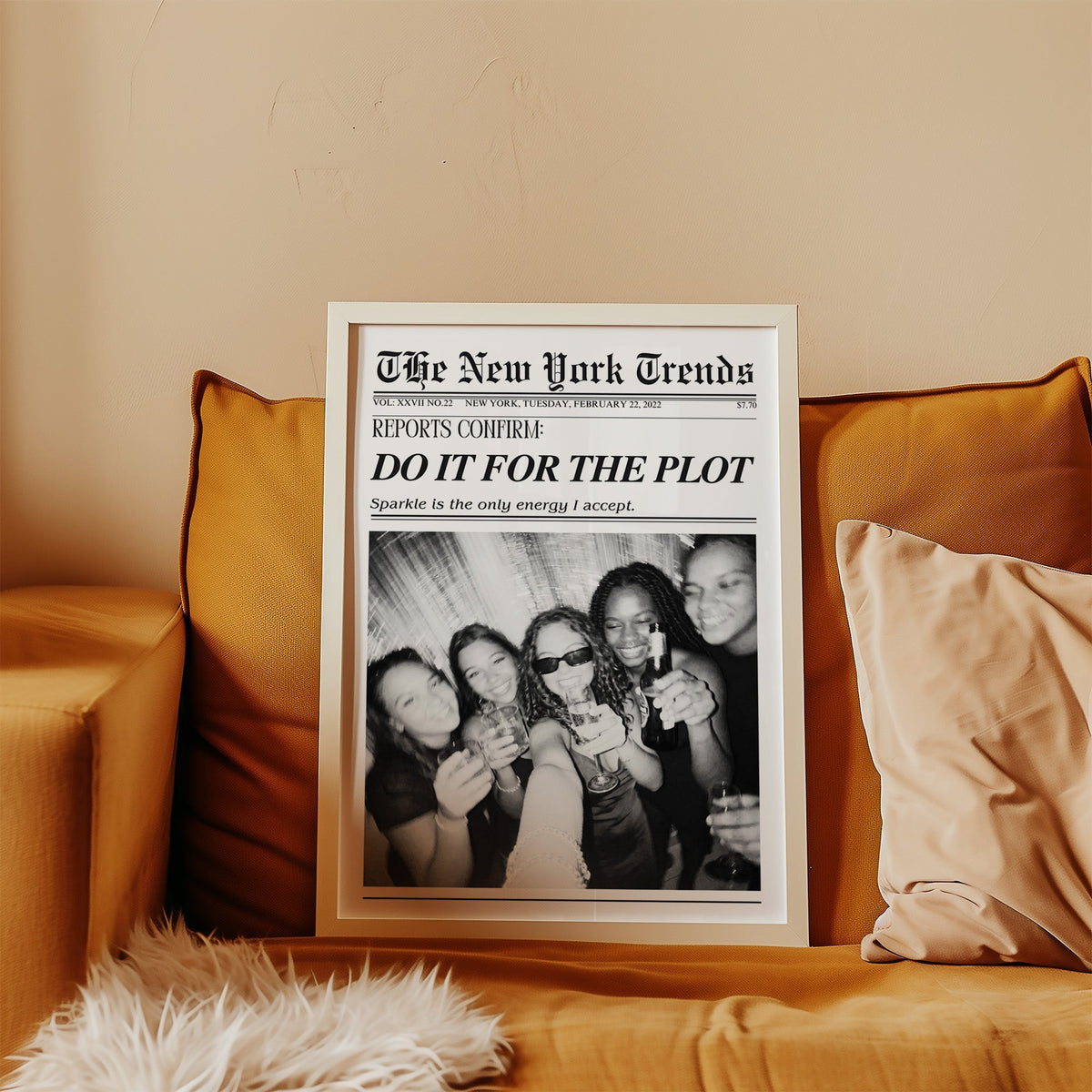 Five friends party selfie mock newspaper print in a white frame leaning on a mustard velvet sofa
