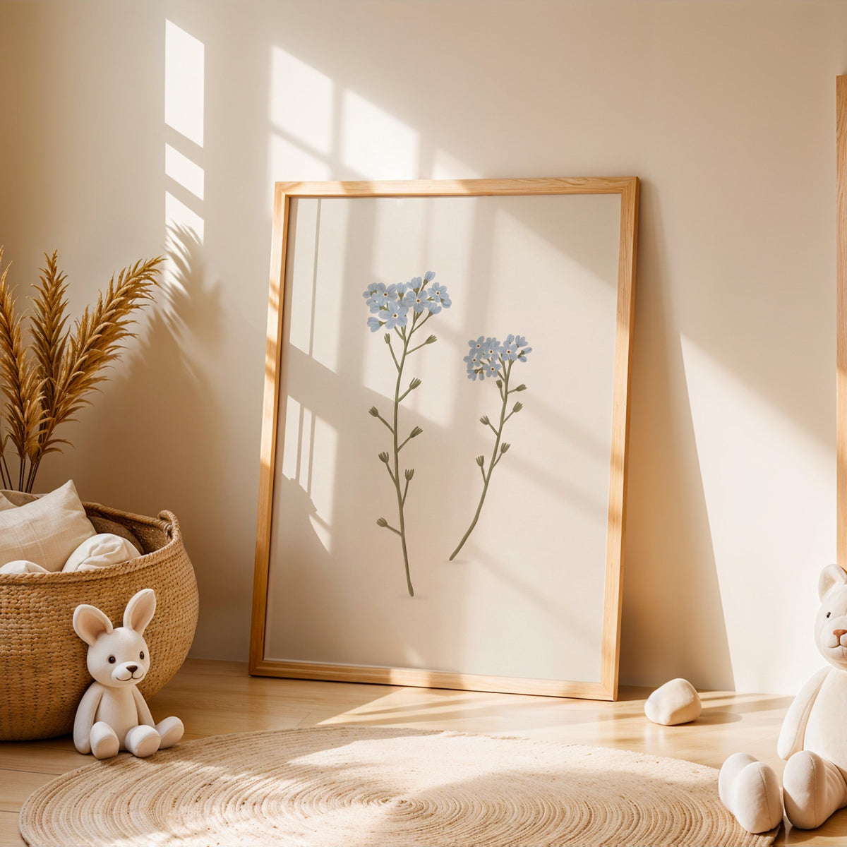 Two blue forget-me-not stems nursery print in an oak frame leaning on a sunlit floor by a woven basket