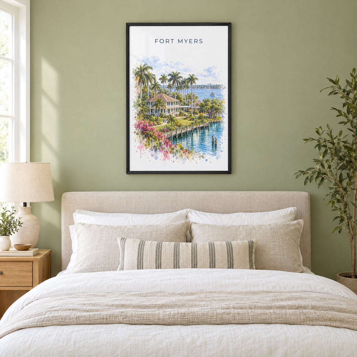 Fort Myers watercolor print in a black frame above an upholstered headboard in a sage green bedroom