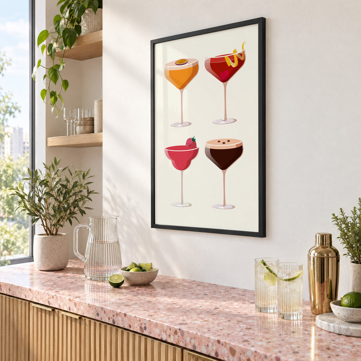 Four coupe cocktails two-by-two grid print in a black frame above a pink terrazzo cocktail counter with limes, seen at an angle