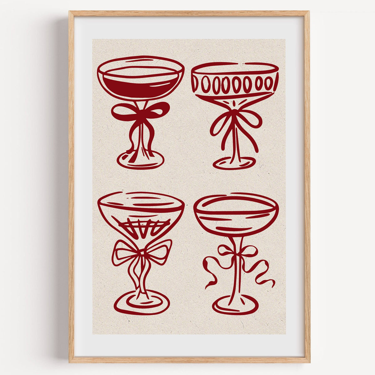 Four red coupe glasses with bows print in a light oak frame on a plain white wall