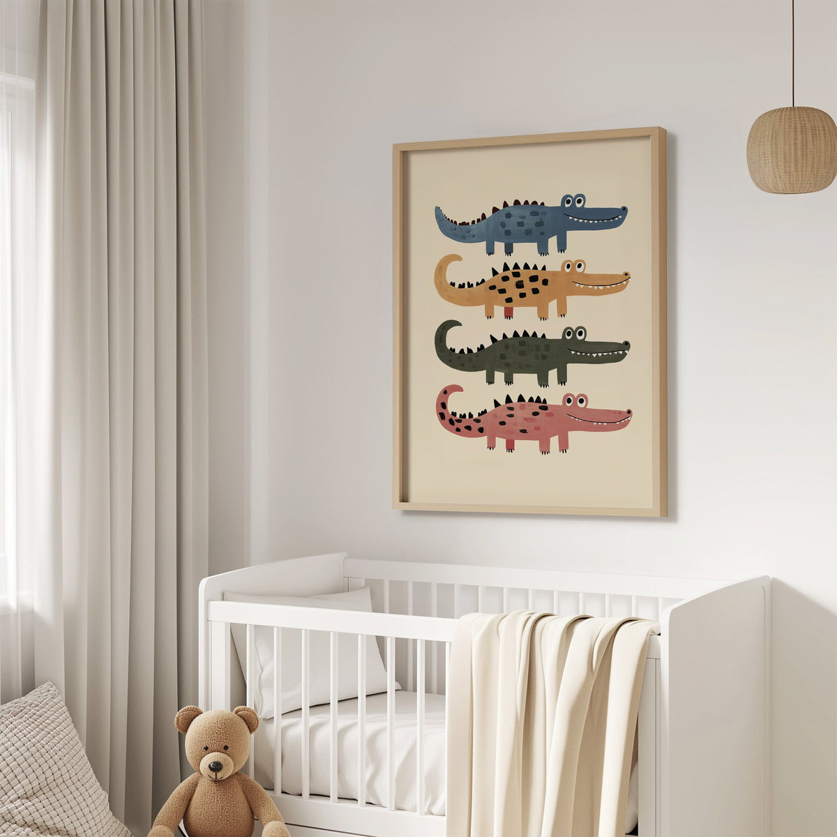 Four stacked crocodiles nursery print in an oak frame above a white crib with a teddy bear